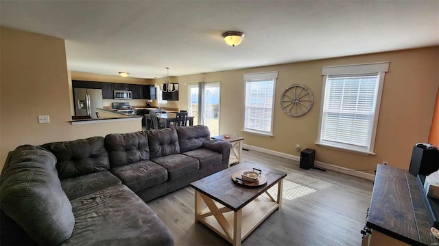 living room featuring light wood-type flooring and baseboards