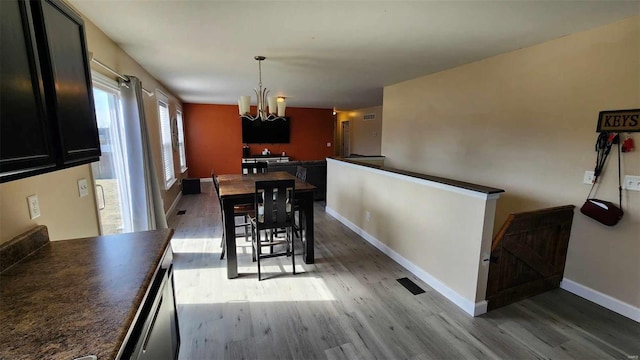 dining space featuring a chandelier, visible vents, light wood-style flooring, and baseboards