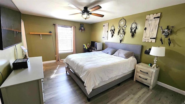 bedroom with ceiling fan, wood finished floors, and baseboards