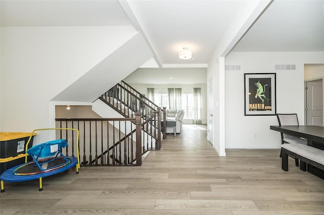 interior space featuring light wood-type flooring, visible vents, and baseboards