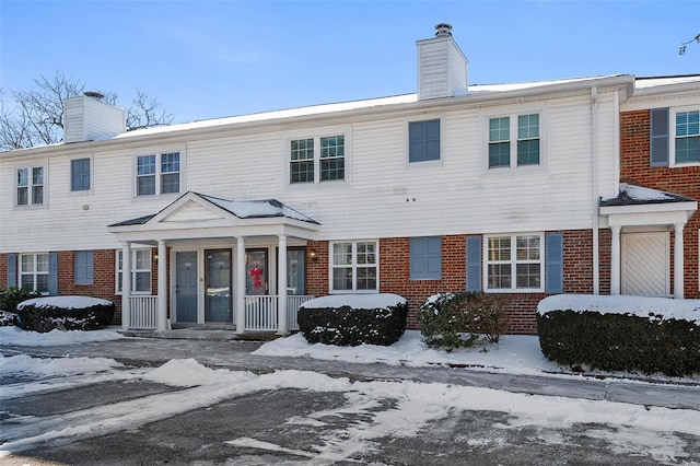 townhome / multi-family property featuring brick siding and a chimney