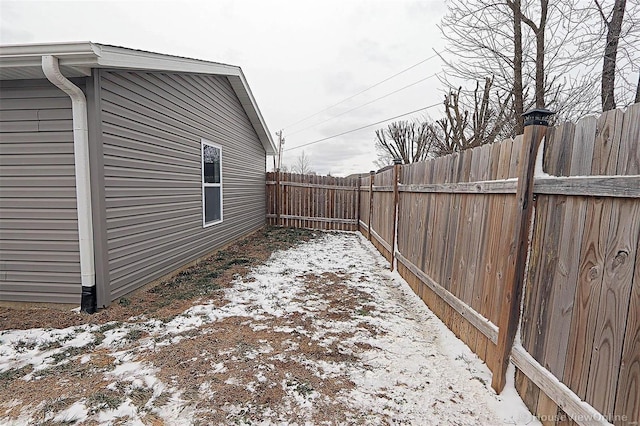 yard layered in snow featuring a fenced backyard