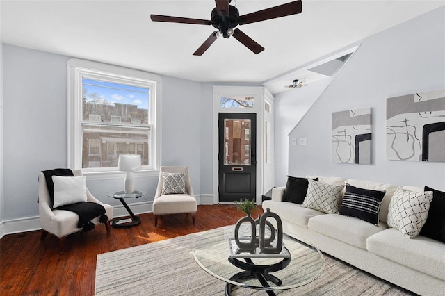 living area featuring baseboards, a ceiling fan, dark wood-type flooring, and lofted ceiling