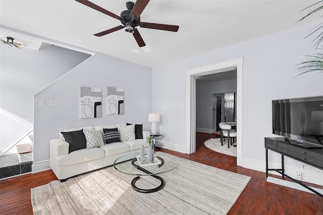 living area with ceiling fan, baseboards, and dark wood-type flooring