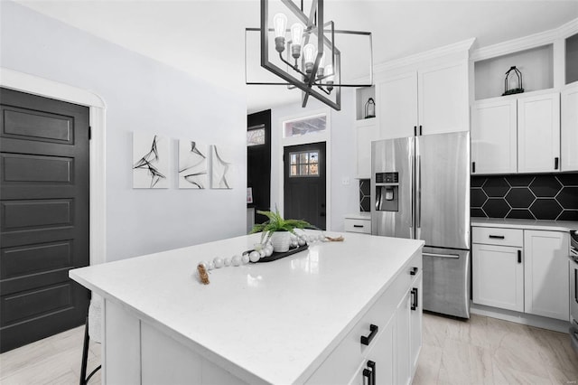 kitchen featuring stainless steel fridge, a kitchen island, and white cabinets