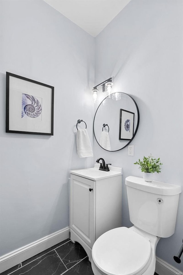 bathroom with marble finish floor, baseboards, vanity, and toilet