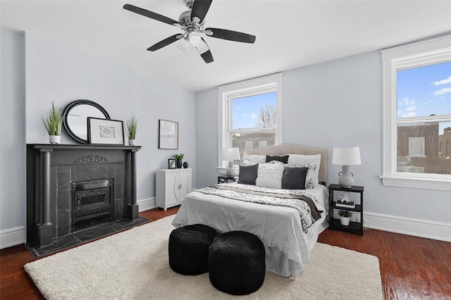 bedroom featuring baseboards, dark wood-type flooring, and multiple windows