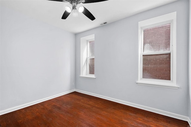 unfurnished room featuring baseboards, ceiling fan, wood finished floors, and visible vents