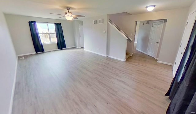 spare room featuring visible vents, wood finished floors, a ceiling fan, and baseboards