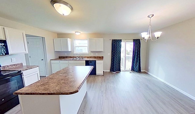 kitchen featuring baseboards, light wood-style floors, black appliances, white cabinetry, and a sink