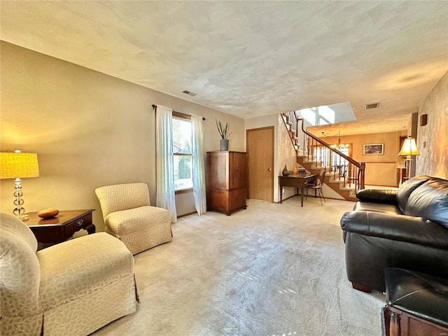 living room featuring stairs, visible vents, and carpet flooring