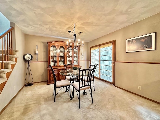 dining room featuring baseboards, stairway, a notable chandelier, and light colored carpet