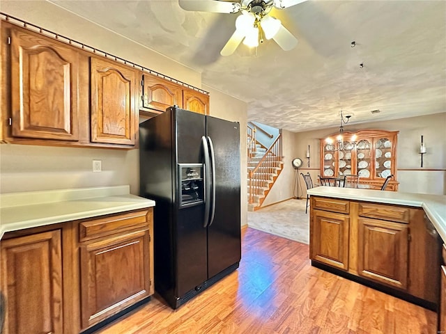 kitchen featuring brown cabinetry, pendant lighting, light countertops, and black fridge with ice dispenser