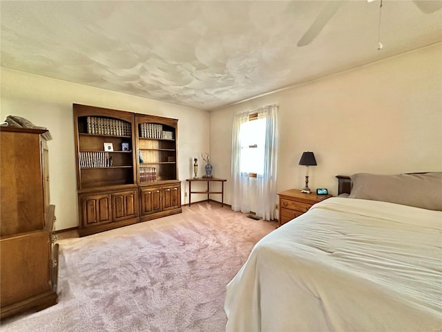 bedroom with a ceiling fan and light colored carpet