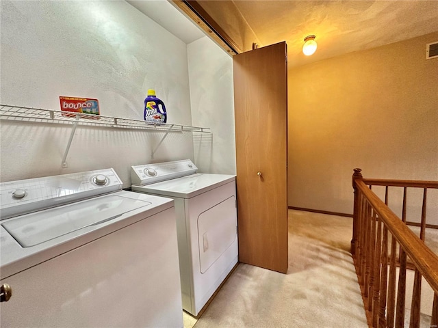 laundry area featuring light carpet, laundry area, washer and clothes dryer, and visible vents