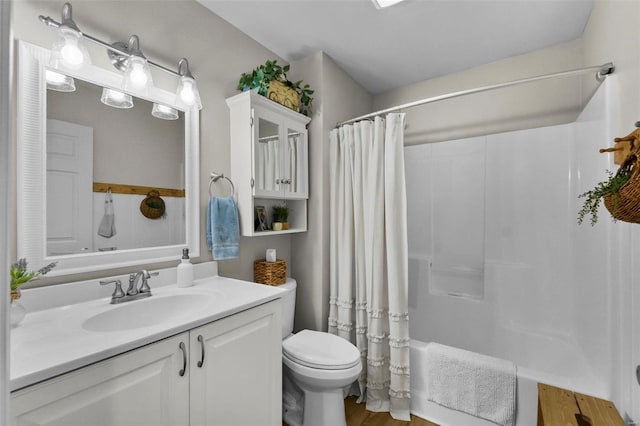 bathroom featuring toilet, shower / bath combo with shower curtain, and vanity