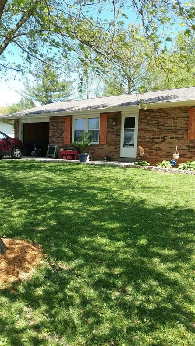 ranch-style home featuring a front lawn, an attached garage, and brick siding