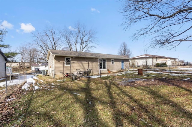 rear view of property featuring entry steps, cooling unit, fence, and a lawn