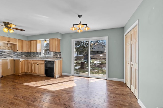 kitchen featuring decorative light fixtures, tasteful backsplash, light brown cabinets, light wood-type flooring, and dishwasher