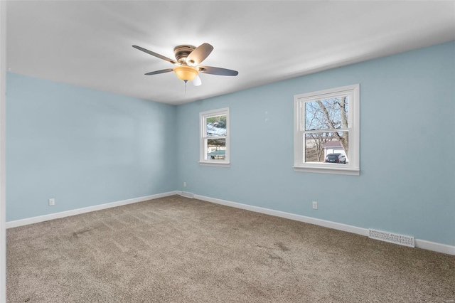 empty room featuring baseboards, visible vents, ceiling fan, and carpet flooring