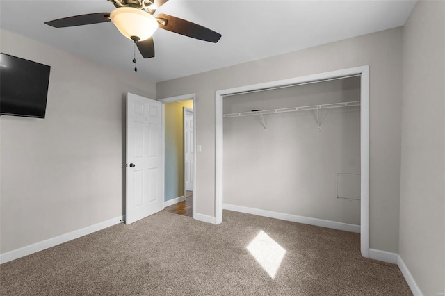 unfurnished bedroom with carpet floors, a closet, a ceiling fan, and baseboards