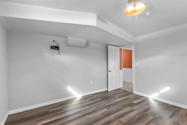 empty room with dark wood-style flooring and baseboards