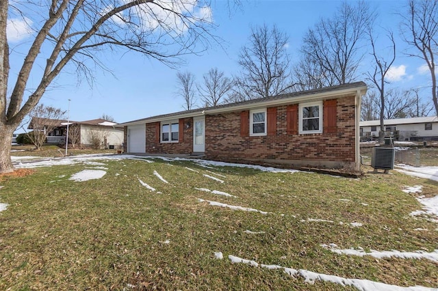 ranch-style house with a garage, brick siding, a front lawn, and central AC unit