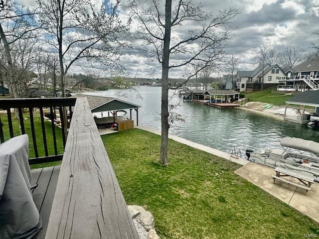 view of dock with a lawn and a water view