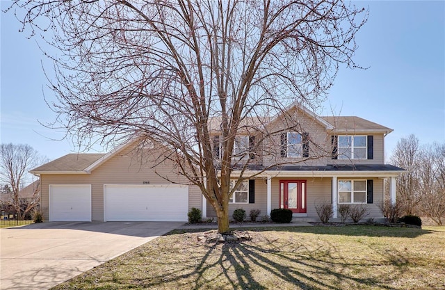 traditional-style home with a garage, concrete driveway, and a front yard