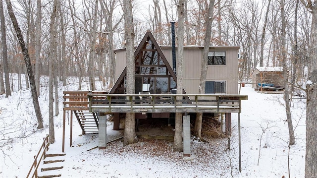 snow covered house with a wooden deck