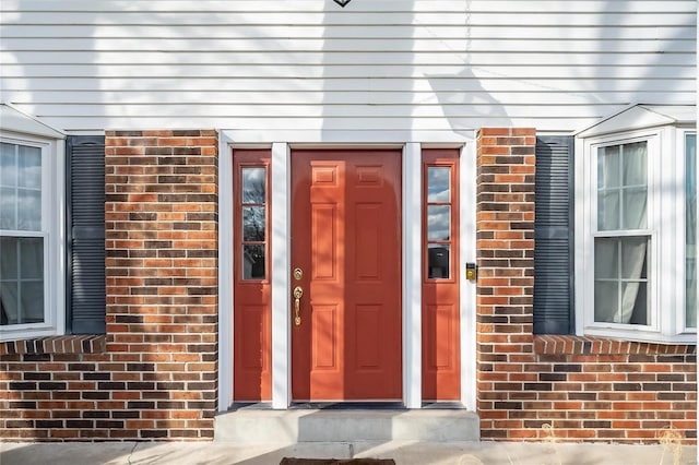 doorway to property with brick siding