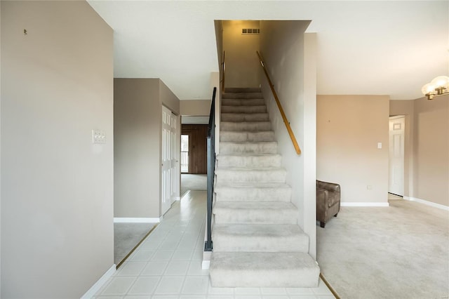 staircase featuring a chandelier, visible vents, carpet, and baseboards