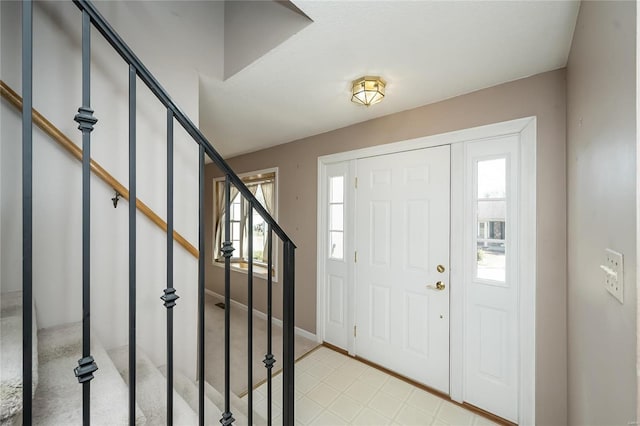 entrance foyer with stairway and baseboards