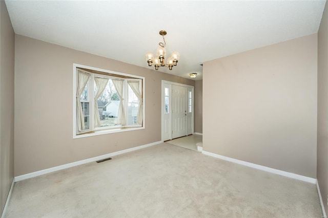 empty room featuring an inviting chandelier, visible vents, baseboards, and light carpet