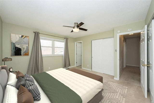 bedroom featuring light colored carpet, baseboards, a closet, and ceiling fan