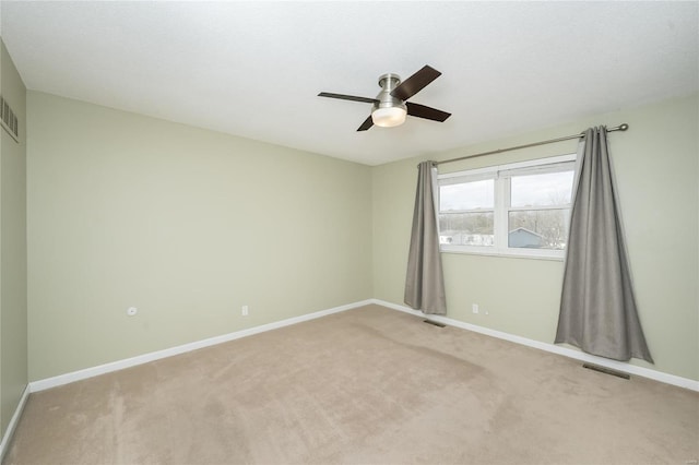 empty room featuring visible vents, baseboards, light colored carpet, and ceiling fan