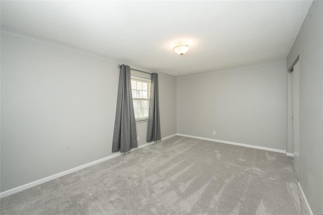 carpeted empty room with baseboards