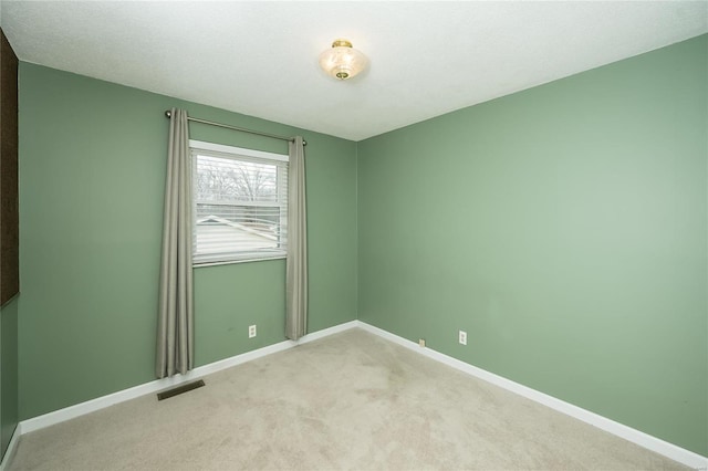 empty room with light carpet, visible vents, and baseboards