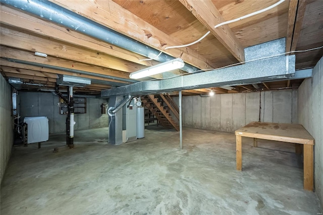 unfinished basement with gas water heater, stairway, and heating unit