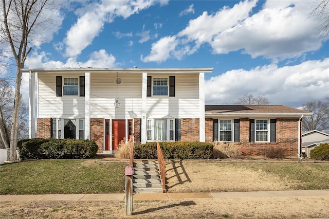 view of front of home featuring a front lawn and brick siding