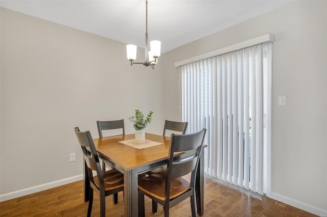 dining area featuring an inviting chandelier, wood finished floors, and baseboards