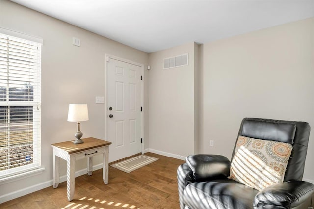 sitting room featuring wood finished floors, visible vents, and baseboards