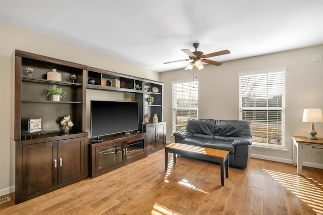 living room featuring visible vents, a ceiling fan, light wood-type flooring, and baseboards