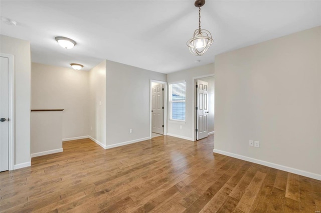 empty room with baseboards and wood finished floors