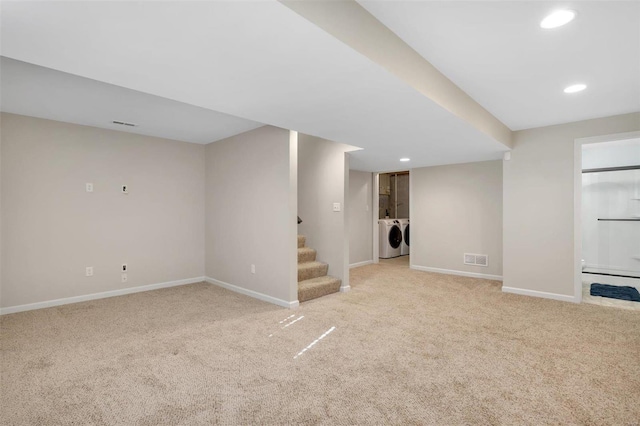 finished below grade area featuring washer and clothes dryer, carpet flooring, stairs, and baseboards