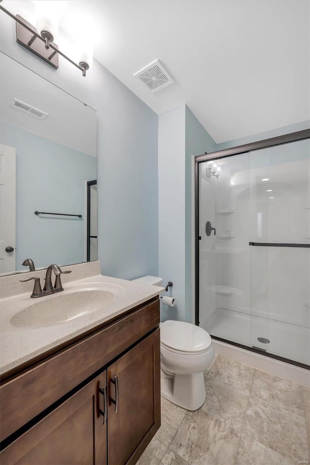 bathroom with vanity, a shower stall, toilet, and visible vents