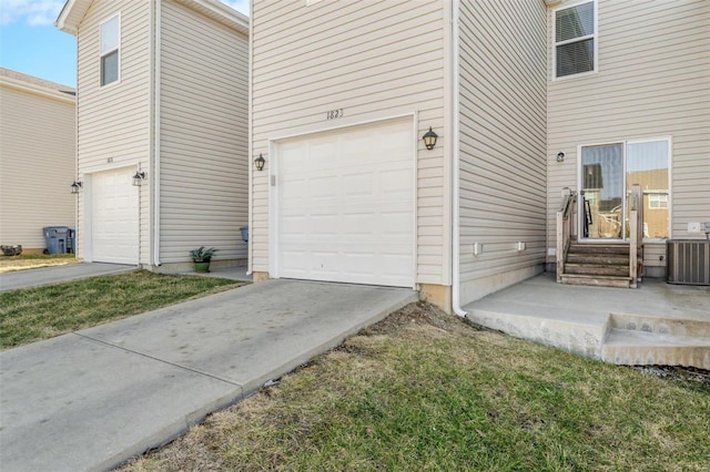 garage featuring central air condition unit and driveway