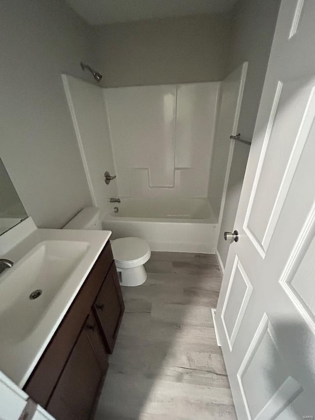 bathroom featuring shower / bathing tub combination, vanity, toilet, and wood finished floors