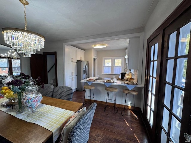 dining room with baseboards, a chandelier, and dark wood finished floors