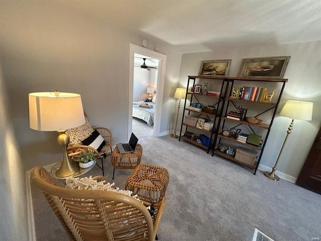 living area featuring carpet flooring, visible vents, and baseboards